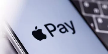 Zu sehen ist ein Apple iPhone mit Apple Pay Logo auf dem Display auf einer Tastatur.