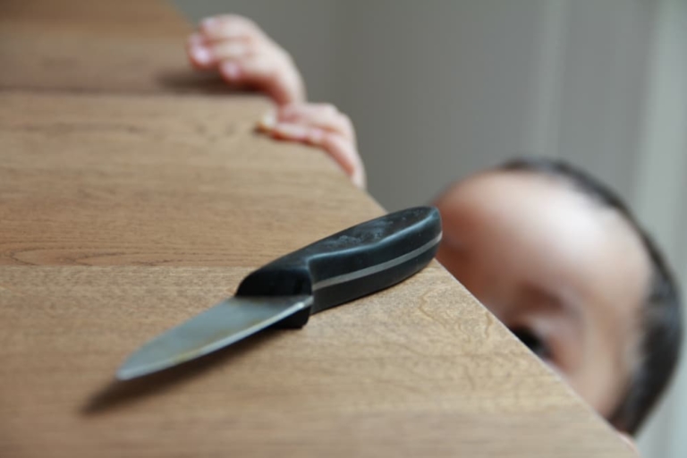 Kind schaut auf Messer