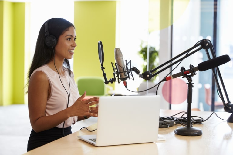 Frau nimmt einen Podcast im Studio auf