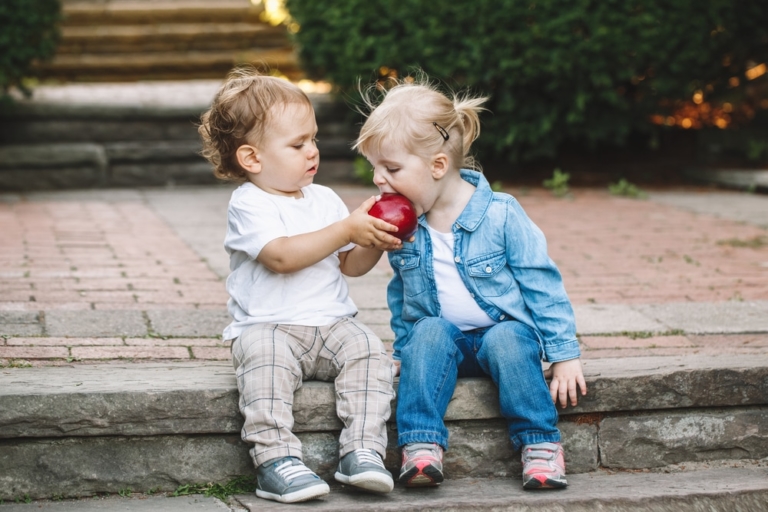 2 Kinder teilen sich ein Apfel