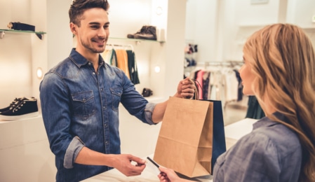 Mann übergibt Einkaufstasche einer jungen Dame