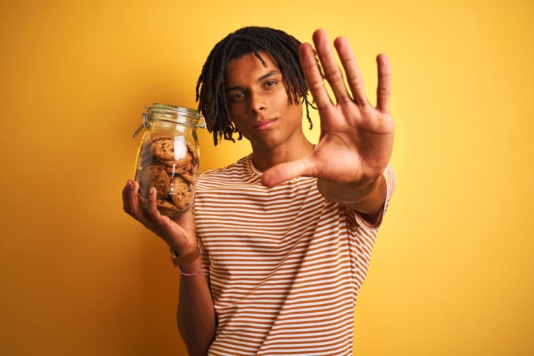 Mann mit Glas in der Hand das mit Cookies gefüllt ist