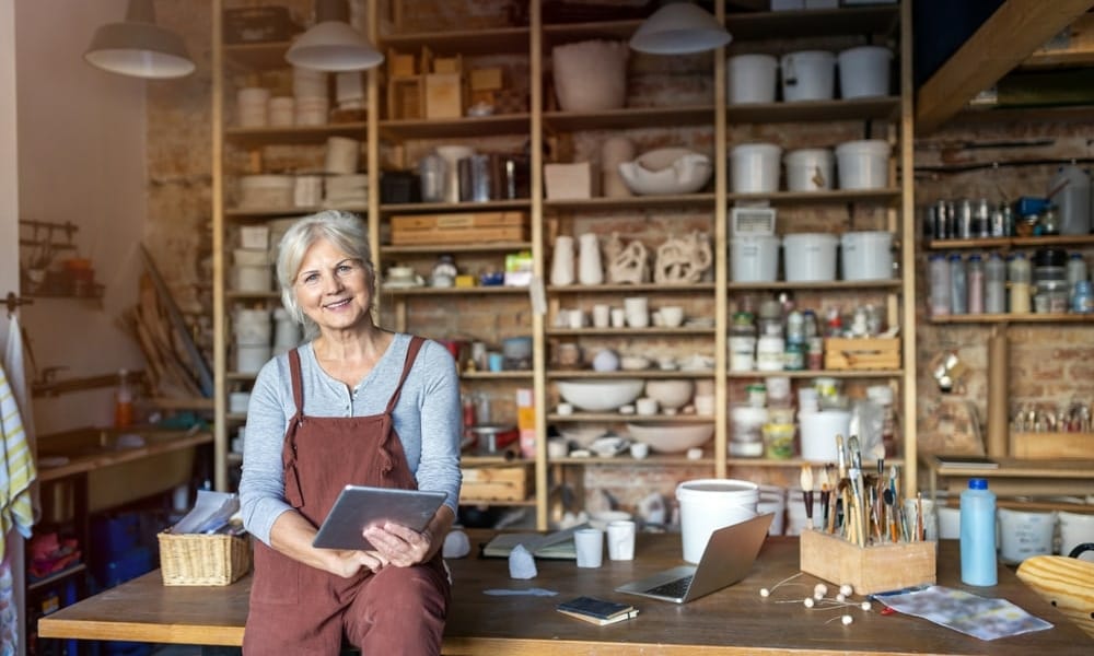 Senior Handwerker mit Tablet-Computer im Kunststudio