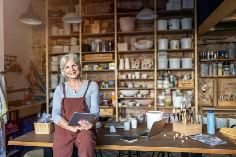 Senior Handwerker mit Tablet-Computer im Kunststudio